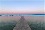 Wooden jetty on the Lake Garda (Lago di Garda) at dawn in Garda in Veneto, Italy