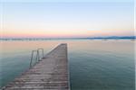 Wooden jetty on Lake Gardo (Lago di Garda) at dawn in Bardolino in Veneto, Italy