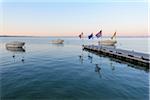 Covered, motorboats docked at jetty at dawn on Lake Garda (Lago di Garda) at Bardolino in Veneto, Italy