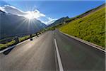 Mountain road with sun at Grossglockner High Alpine Road in the Hohe Tauern National Park, Carinthia, Austria