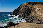 Scenic view of rocky shoreline and breaking waves at Byron Bay in New South Wales, Australia