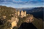 Sunlight reflecting on the Three Sisters rock formations and scenic view of the Blue Mountains National Park in New South Wales, Australia