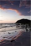 Silhouette of coastal shoreline and beach at Cape Tribulation at sunrise in Daintree National Park, Australia