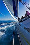 Group of people on a sailboat, sailing on the choppy waters around the Whitsunday Islands in Queensland, Australia