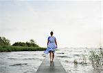 Woman posing in the Frisian lake district in vintage dress, Sneek, Friesland, Netherlands