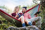 Couple relaxing in hammock, smiling, Krakow, Malopolskie, Poland, Europe