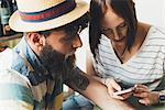 Couple looking at smartphone in bar