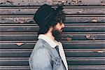 Profile of young man, standing in front of shutter