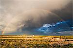 Sunset rainbow amid dramatic clouds over New Mexico desert landscape, USA