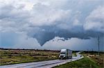 Truck on wet road, tornado lifting south of Waynoka in background, Oklahoma, USA