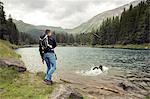 Man with dog hiking by lake, Tirol, Steiermark, Austria, Europe