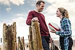 Father and daughter at beach, talking, daughter holding rugby ball