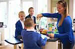 Mother pouring breakfast cereal for son in kitchen