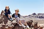 Boy and mother sitting on rocks at Mount Teide, Tenerife, Canary Islands