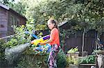 Teenage girl squirting water gun in garden