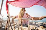 Rear view of woman sitting on beach relaxing, Palma de Mallorca, Islas Baleares, Spain, Europe