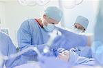 Surgeons operating on female patient in operating room