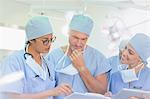 Surgeons reviewing paperwork in operating room