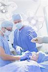 Surgeon reaching for surgical scissors in operating room