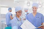 Female surgeons reviewing paperwork in operating room