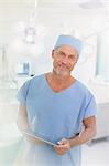 Portrait male surgeon using digital tablet in operating room