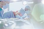 Focused male surgeon performing surgery on female patient in operating room