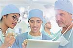 Surgeons using digital tablet in operating room