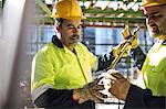 Construction workers looking at metal rod