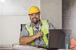 Construction worker using laptop at desk