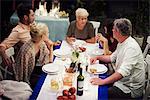 Group of people sitting at table, enjoying meal