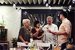 Group of people standing beside dinner table, holding wine glasses