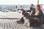 Couple sitting with dog looking away