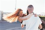 Man carrying smiling woman in arms