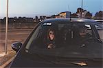 Couple in car at night using smartphone