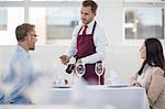 Waiter showing bottle of wine to diner in restaurant