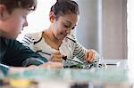 Students soldering circuit board in classroom