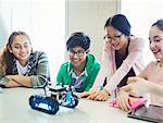 Students programming and testing robotics in classroom