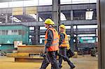 Male workers walking in steel factory