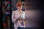 Female IT technician using futuristic digital tablet in server room