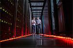IT technicians talking and walking in dark server room