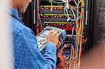 IT technician using fiber optic tester equipment in server room