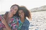 Portrait smiling, confident mother and daughter hugging on sunny, summer beach