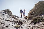 Couple walking on sunny summer beach path