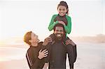 Portrait smiling family in wet suits on sunny summer beach