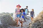 Family walking on sunny summer beach path