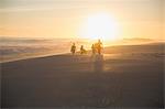 Silhouette family walking on sunny summer sunset beach
