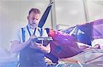 Male mechanic performing diagnostics with equipment near airplane in hangar