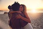 Affectionate couple hugging on sunny sunset summer beach