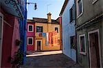 Narrow alley with colourful facades and clothes on washing line in Venice, Italy.