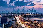 Cityscape of the Dubai, United Arab Emirates at dusk, with highway across the marina and skyscrapers in the distance.